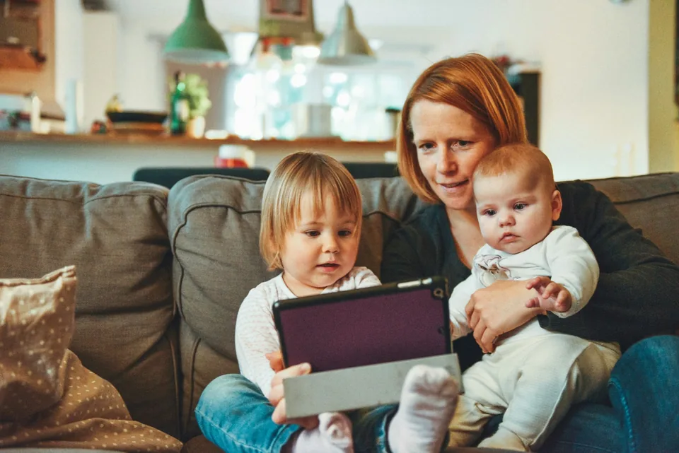 A parent reading with two young children at home