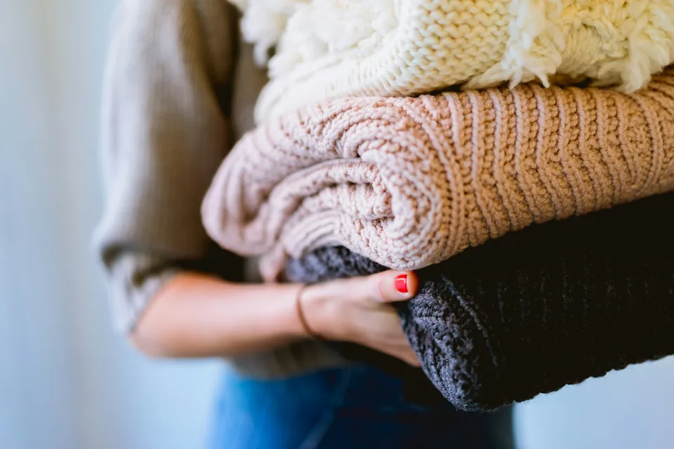 A person folding towels at home
